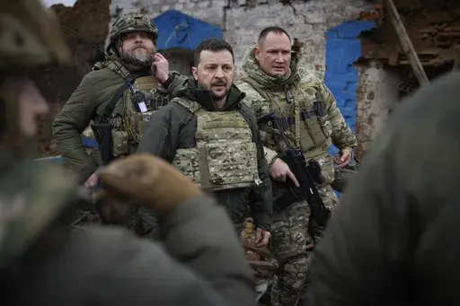 In this photo provided by the Ukrainian Presidential Press Office, Ukrainian President Volodymyr Zelenskyy, centre, during his visit to Zaporizhzhia region, the site of fierce battles with the Russian troops in Ukraine, Sunday, Feb. 4, 2024. (Ukrainian Presidential Press Office via AP)