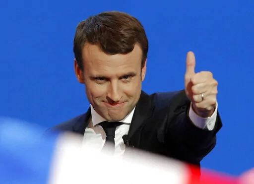 French centrist presidential candidate Emmanuel Macron thumbs up as he addresses his supporters at his election day headquarters in Paris, April 23, 2017. French President Emmanuel Macron hasn't officially declared that he's a candidate for April's presidential election yet. Critics say he's unfairly using his taxpayer-funded presidential pulpit to campaign for a second term while dragging out his widely expected announcement as long as possible. (AP Photo/Christophe Ena, File)