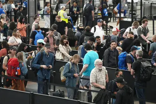Travelers wait in long lines at a security checkpoint in Denver International Airport Tuesday, July 5, 2022, in Denver. The Fourth of July holiday weekend jammed U.S. airports with the biggest crowds since the pandemic began in 2020. (AP Photo/David Zalubowski)