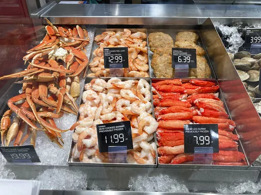 Fresh seafood is shown for sale at a grocery store, Wednesday, July 27, 2022, in Surfside, Fla. This year has been full of economic uncertainty for many. High inflation has affected the cost of living, making housing, food and gas more expensive. Now that we’re near the end of the year, people may be setting financial goals for 2023. Consider looking at the current state of the economy and using that to shape your goals. (AP Photo/Wilfredo Lee)