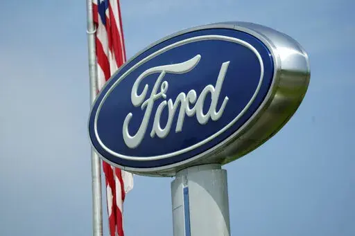 A Ford logo is seen on signage at Country Ford in Graham, N.C., Tuesday, July 27, 2021.  Ford is recalling about 200,000 cars in the U.S., Wednesday, Jan. 19, 2022,  to fix a problem that can stop the brake lights from turning off. The recall covers certain 2014 and 2015 Ford Fusion and Lincoln MKZ midsize cars as well as some 2015 Mustangs. (AP Photo/Gerry Broome)