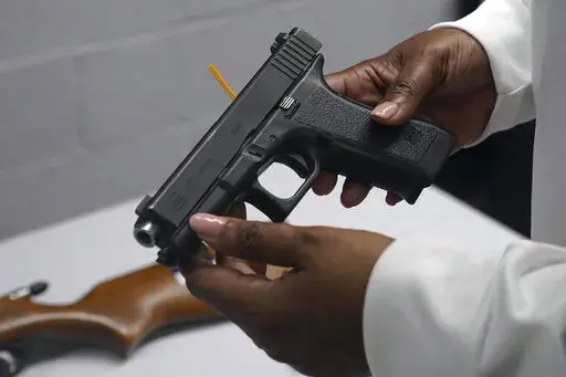 A handgun from a collection of illegal guns is reviewed during a gun buyback event in Brooklyn, N.Y., May 22, 2021. The Supreme Court, Thursday, June 23, 2022, struck down a restrictive New York gun law in a major ruling for gun rights. (AP Photo/Bebeto Matthews, FIle)