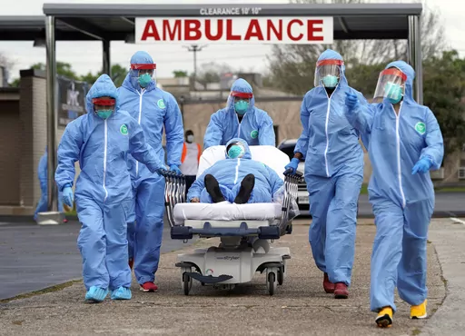 A person is taken on a stretcher into the United Memorial Medical Center after going through testing for COVID-19 Thursday, March 19, 2020, in Houston. On the third anniversary of the COVID-19 pandemic in 2023, the virus is still spreading and the death toll is nearing 7 million worldwide. Yet most people have resumed their normal lives, thanks to a wall of immunity built from infections and vaccines. (AP Photo/David J. Phillip, File)