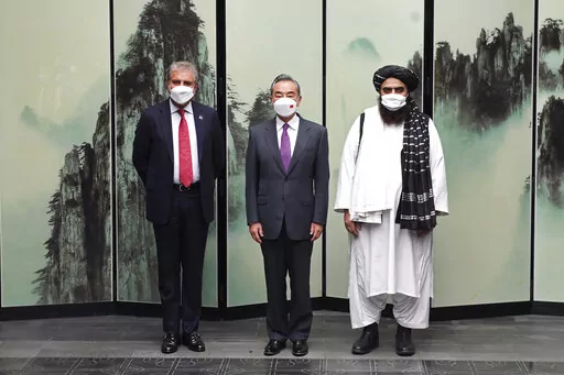 In this photo released by Xinhua News Agency, Chinese Foreign Minister Wang Yi pose for photos next to Pakistan Foreign Minister Shah Mahmood Qureshi at left and Taliban-appointed Afghanistan Foreign Minister Amir Khan Muttaqi at right during a meeting held in Tunxi district in eastern China's Anhui province on Wednesday, March 30, 2022. Chinese leader Xi Jinping on Thursday issued strong backing for Afghanistan at a regional conference, while making no mention of human rights abuses by the coun