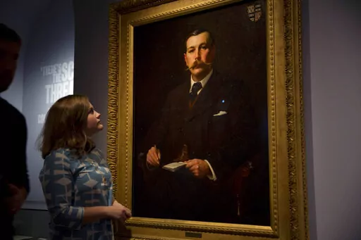 A Museum of London employee poses for photographers next to an 1897 oil on canvas portrait of Sherlock Holmes author Sir Arthur Conan Doyle by illustrator Sidney Paget on display as part of the exhibition "Sherlock Holmes: The Man Who Never Lived and Will Never Die" at the Museum of London in London, Oct. 16, 2014. Sherlock Holmes is finally free to the public in 2023. The long dispute on contested copyright on Doyle's tales of a whip-smart detective will come to an end in 2022, as the final She