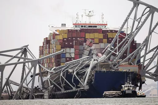 A cargo ship is stuck under the part of the structure of the Francis Scott Key Bridge after the ship hit the bridge Wednesday, March 27, 2024, in Baltimore, Md. On Thursday, March 28, The Associated Press reported on stories circulating online incorrectly claiming the captain of Dali, the container ship that crashed into Baltimore’s Francis Scott Key Bridge, is Ukrainian. (AP Photo/Steve Helber)