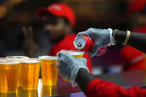 Staff member pours a beer at a fan zone ahead of the FIFA World Cup, in Doha, Qatar Saturday, Nov. 19, 2022. The last-minute decision to ban the sale of beer at World Cup stadiums in Qatar is the latest example of some the tensions that have played out ahead of the tournament. Qatari officials have for long said they were eager to welcome everybody but that visitors should also respect their culture and traditions. (AP Photo/Petr Josek)