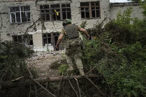 A Ukrainian serviceman of the 68th Oleksa Dovbush hunting brigade runs to his position in the recently retaken village of Blahodatne, Ukraine, Saturday, June 17, 2023. (AP Photo/Evgeniy Maloletka)