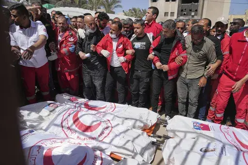 Mourners gather around the bodies of 8 Red Crescent emergency responders, recovered in Rafah a week after an Israeli attack, as they are transported for burial from a hospital in Deir al-Balah, Gaza Strip, on Monday, March 31, 2025. (AP Photo/Abdel Kareem Hana)