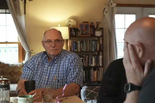 Doug Whitney, left, looks at his son, Brian, in Manson, Wash., on Nov. 5, 2022. Doug inherited the same gene mutation that gave Alzheimer's disease to his mother, brother and generations of other relatives by the unusually young age of 50. Doug is a healthy 73, his mind still sharp. Somehow, he escaped his genetic fate. Brian, who also inherited the devastating family gene, has reached the fateful age of 50 without symptoms but knows that’s no guarantee. (AP Photo/Shelby Lum)