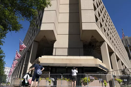 People take photos of the FBI building headquarters in Washington, Aug. 13, 2022. A federal judge has held veteran investigative reporter Catherine Herridge in civil contempt for refusing to divulge her source for a series of Fox News stories about a Chinese American scientist who was investigated by the FBI but never charged. (AP Photo/Jose Luis Magana, File)