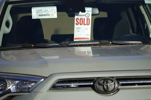 A sold tag hangs from the inside rear-view mirror of a 2022 4Runner sports-utility vehicle as it sits in an empty storage lot at a Toyota dealership Sunday, Feb. 27, 2022, in Englewood, Colo. (AP Photo/David Zalubowski, File)