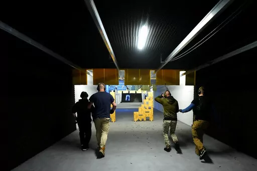 Instructors train Ukrainian national at a shooting range in Brno, Czech Republic, Sunday April 10, 2022. Since Russia launched its brutal attack against Ukraine, Ukrainians living across Czech Republic have been arriving in the second largest Czech city of Brno. They have come for courses designed to teach them skills to safely handle lethal rifles while being able to inflict damage on their enemy. (AP Photo/Petr David Josek)