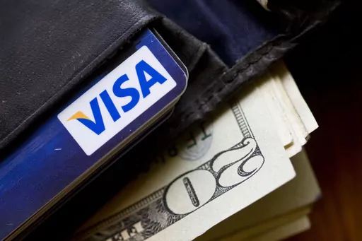 In this Feb. 2, 2011, file photo, a wallet containing cash and a Visa card is displayed in Surfside, Fla. Freelancers, service workers, people who work seasonal jobs and those who earn money based on tips, royalties or commissions often experience fluctuating income during a month, season or year. These kinds of workers can adjust their budget for leaner times as well as create a robust savings plan for current expenses and the future. The first step is to begin tracking income and expenses, so 