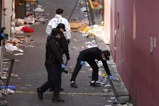 South Korean investigators inspect the scene of a deadly accident following Saturday night's Halloween festivities in Seoul, South Korea, Monday, Oct. 31, 2022. A crowd surge killed more than 150 people during Halloween festivities in Seoul over the weekend in the country’s worst disasters in years. (AP Photo/Lee Jin-man)