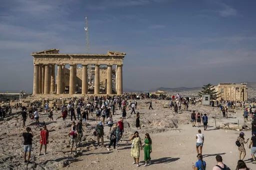 Tourists visit the Acropolis hill with the 2,500-year-old Parthenon temple on the left, and the ancient Erechtheion temple on the right, in Athens , on Tuesday, Oct. 11, 2022. Greece is on course to beat its annual record for tourism revenue as southern European Union members made a surprise recovery following a two-year travel slump caused by the pandemic. (AP Photo/Petros Giannakouris)
