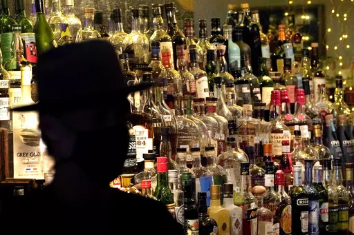 Bottles of alcohol sit on shelves at a bar in Houston on June 23, 2020. Moderate drinking was once thought to have benefits for the heart, but better research methods starting in the 2010s have thrown cold water on that. (AP Photo/David J. Phillip, File)