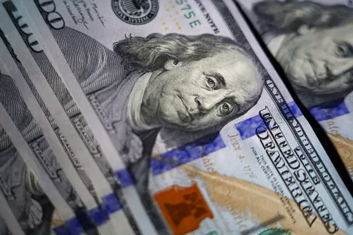 The likeness of Benjamin Franklin is seen on U.S. $100 bills, Thursday, July 14, 2022, in Marple Township, Pa. As we kick-start 2023, many parents are rebalancing their budgets and looking for ways to save money amid inflation. Parents who often look forward to getting sizable tax refunds may end up with a noticeable reduction. (AP Photo/Matt Slocum, File)