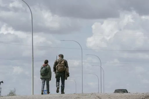 This image released by HBO shows Pedro Pascal, right, and Bella Ramsey in a scene from the series "The Last of Us." (HBO via AP)