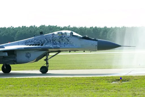 Slovak Air Force MiG-29 goes through a water gate during an airshow in Malacky, Slovakia, Saturday, Aug. 27, 2022. Former Soviet satellite Slovakia has been a NATO member since 2004, but the reality of belonging to the world’s biggest military alliance really kicked in after Russia’s invasion of Ukraine a year ago. The small central European country now hosts thousands of NATO troops while allied aircraft patrol its skies. (AP Photo/Petr David Josek,File)