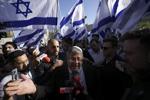 Israeli lawmaker Itamar Ben-Gvir, center, surrounded by right wing activists with Israeli flags, speaks to the media as they gather for a march in Jerusalem, Wednesday, April 20, 2022. Major Jewish American organizations, traditionally a bedrock of support for Israel, have expressed alarm over the presumptive government's far-right character. Given American Jews' predominantly liberal political views and affinity for the Democratic Party, these misgivings could have a ripple effect in Washington