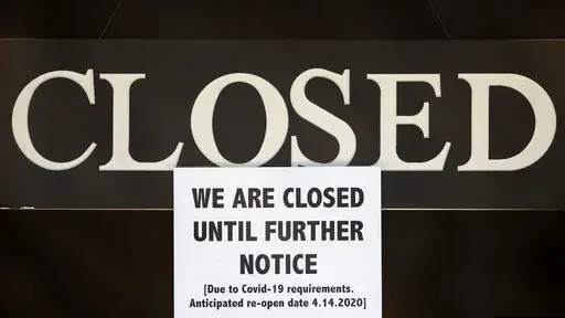 In this April 2, 2020 file photo, a notice of closure is posted at The Great Frame Up in Grosse Pointe Woods, Mich. President Donald Trump rolled out the Paycheck Protection Program to catapult the U.S. economy into a quick recovery from the coronavirus pandemic. President Joe Biden tweaked it to try to direct more of the money to poorer communities and minority-owned companies. Now, almost two years after the program made its debut, what did taxpayers get for the $800 billion? (AP Photo/Paul Sa