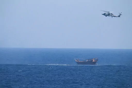 A U.S. Navy Seahawk helicopter flies over a stateless dhow later found to be carrying a hidden arms shipment in the Arabian Sea, May 6, 2021. The U.S. Navy's Mideast-based 5th Fleet will begin Tuesday, July 5, 2022, to offer rewards for information that could help sailors intercept weapons, drugs and other illicit shipments across the region. The program launches against the backdrop of tensions over Iran’s nuclear program and Tehran’s arming of Yemen’s Houthi rebels. (U.S. Navy via AP, Fi