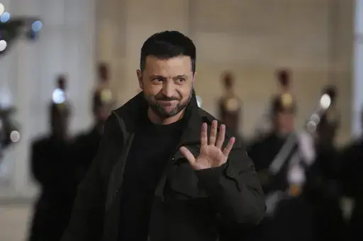 Ukraine's President Volodymyr Zelenskyy waves as he arrives at the Elysee Palace, Saturday, Dec. 7, 2024 in Paris. (AP Photo/Michel Euler)