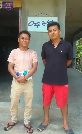 Aung San Oo, left, and Myo Myint Oo, pose for a picture in front of the office of the Tanintharyi Weekly Journal published by Dawei Watch media, in Dawei township in Tanintharyi region, Myanmar, in 2020. A military court in Myanmar has given a life prison sentence to a local journalist and sentenced one of his colleagues to 20 years after convicting them under a counterterrorism law, their editor said Wednesday. (Zaw Zaw (Myeik) via AP)
