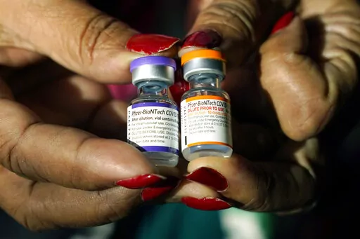A nurse holds a vial of the Pfizer COVID-19 vaccine for children ages 5 - 11, right, and a vial of the vaccine for adults, which have different colored labels, at a vaccination station in Jackson, Miss., Tuesday, Feb. 8, 2022. Pfizer’s COVID-19 vaccine gave children 5 and older strong protection against hospitalization and death even during the omicron surge that hit youngsters especially hard, according to new data from the Centers for Disease Control and Prevention released on Tuesday, March