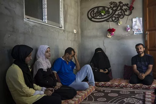 The Zorob family sits inside their one-room hut, covered in nylon sheets in Khan Younis, southern Gaza Strip, Monday, Aug. 28, 2023. The Gaza Strip's displaced families await the completion of nearly 1,400 Egyptian-sponsored housing units, a project mired in political disputes between the Palestinian Authority and Gaza's Hamas-run government. The Zorob family, like thousands of others, remains caught in the crossfire, living in makeshift conditions while nearly completed apartments stand empty.(