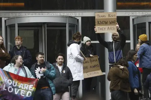 People celebrate outside a Seattle federal courthouse after a second federal judge paused President Donald Trump's order against gender-affirming care for youth on Friday, Feb. 14, 2025 in Seattle.. (AP Photo/Manuel Valdes)