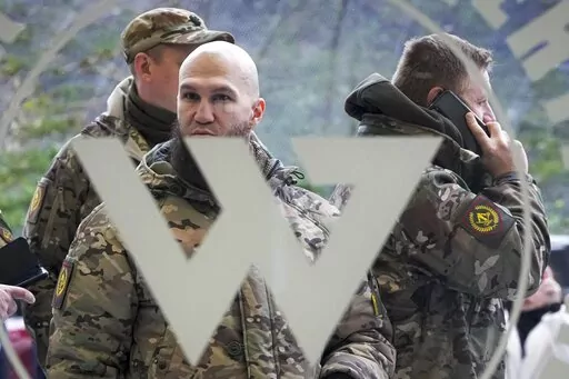 Visitors wearing military camouflage stand at the entrance of the 'PMC Wagner Centre', which is associated with businessman and founder of the Wagner private military group Yevgeny Prigozhin, during the official opening of the office block during National Unity Day, in St. Petersburg, Russia, on Nov. 4, 2022. Russia's Wagner Group, a private military company led by Yevgeny Prigozhin, a rogue millionaire with longtime links to Russia's President Vladimir Putin, has played an increasingly visible 