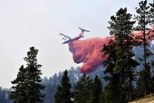 An aircraft drops fire retardant to slow the spread of the Richard Spring fire, east of Lame Deer, Mont., on Aug. 11, 2021. A legal dispute in Montana could drastically curb the government’s use of aerial fire retardant to combat wildfires. Environmentalists have sued the U.S. Forest Service over waterways being polluted with the potentially toxic red slurry that’s dropped from aircraft. Forest Service officials have acknowledged more than 200 cases of retardant landing in water. (AP Photo/M