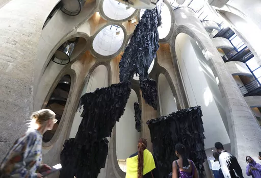 An installation by Malagasy artist Joel Andrianomearisoa "The Five Continents of All Our Desires," is seen in the Zeitz Museum of Contemporary Art Africa in Cape Town, South Africa, Wednesday, Sept. 7, 2022. The work transforms the towering atrium of the museum with black silk paper suspended in the museum's multi-story central atrium.(AP Photo/Nardus Engelbrecht)