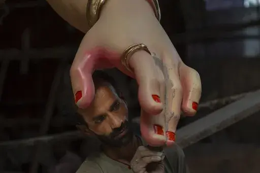 An artist works on an idol of the elephant-headed Hindu god Ganesha inside a workshop ahead of Ganesh Chaturthi festival in Mumbai, India, Wednesday, Sept. 4, 2024. (AP Photo/Rafiq Maqbool)