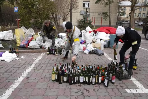 Members of civil defense prepare Molotov cocktails in a yard in Kyiv, Ukraine, Sunday, Feb. 27, 2022. A Ukrainian official says street fighting has broken out in Ukraine's second-largest city of Kharkiv. Russian troops also put increasing pressure on strategic ports in the country's south following a wave of attacks on airfields and fuel facilities elsewhere that appeared to mark a new phase of Russia's invasion. (AP Photo/Efrem Lukatsky)