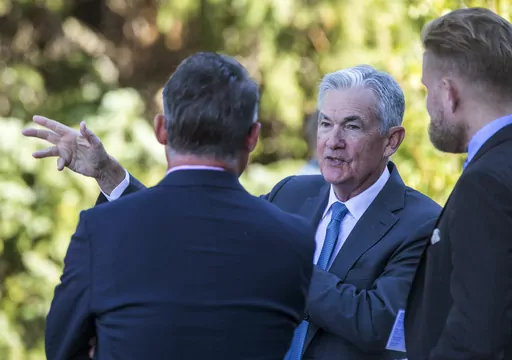 Federal Reserve Chair Jerome Powell, center, talks with attendees of the central bank's annual symposium at Jackson Lake Lodge in Grand Teton National Park, Aug. 26, 2022. in Moran, Wyo. As Powell returns to Jackson Hole this week, the U.S. economy's resilience has raised the prospect that the Fed will need to keep its key rate higher for longer than had been expected. (AP Photo/Amber Baesler, File)