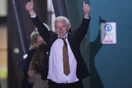 WikiLeaks founder Julian Assange gestures after landing at RAAF air base Fairbairn in Canberra, Australia, June 26 2024. The abrupt guilty plea by WikiLeaks founder Julian Assange was the culmination of negotiations that began a year and a half ago and accelerated in recent months.(AP Photo/Rick Rycroft, File)