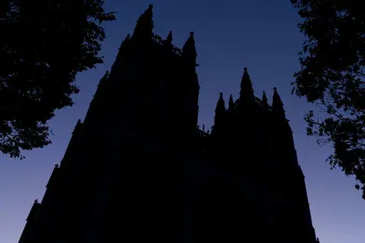 FILE - The Washington National Cathedral is seen at dawn in Washington on Friday, Nov. 5, 2021. Amid the surge of coronavirus cases across the U.S., this and many other churches have cancelled in-person Christmas services, disappointing pastors and churchgoers who consider them an annual highlight. (AP Photo/Andrew Harnik)