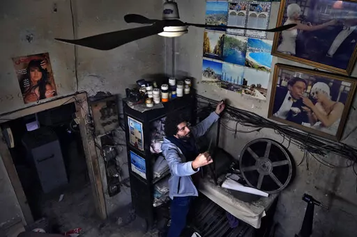 Kassem Istanbouli, actor, director and founder of the Tyro Association for Arts, inspects a film at Empire Cinema in Tripoli, Lebanon, Feb. 16, 2022. Often known in recent years for sectarian and other violence, Tripoli seems an unlikely place for a cultural revival, but it has a long cinematic tradition, once boasting 35 movie houses and Lebanon's first cinema. Istanbouli, is seeking to restore some of that past glory by turning the city’s long abandoned Empire Cinema into a national theater.