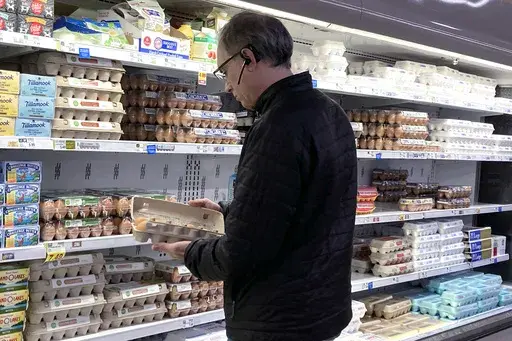 A shopper checks eggs before he purchases at a grocery store in Glenview, Ill., Tuesday, Jan. 10, 2023. (AP Photo/Nam Y. Huh, File)