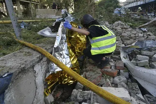 A police officer covers a body of a man who was killed by a Russian attack on Nova Poshta delivery in Kharkiv, Ukraine, Sunday, June 30, 2024. One person was killed and several were injured. (AP Photo/Andrii Marienko)