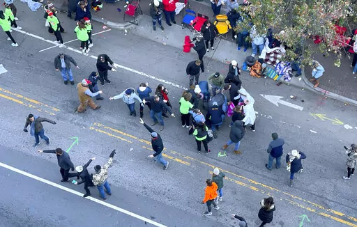Personnel rush to where a person was injured during the Raleigh Christmas Parade on Hillsborough Street in Raleigh, N.C., Saturday, Nov. 19, 2022. Witnesses say people attending the Raleigh Christmas Parade heard the truck's driver screaming that he had lost control of the vehicle and couldn’t stop it before the crash.( (Ethan Hyman/The News & Observer via AP)
