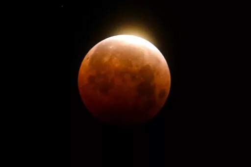 Light shines from a total lunar eclipse over Santa Monica Beach in Santa Monica, Calif., Wednesday, May 26, 2021. A total lunar eclipse will grace the night skies this weekend, providing longer than usual thrills for stargazers across North and South America. The celestial action unfolds Sunday night, May 15, 2022 into early Monday morning, with the moon bathed in the reflected red and orange hues of Earth’s sunsets and sunrises for about 1 1/2 hours, the longest totality of the decade. It wil