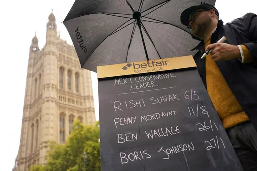A bookmaker takes bets for the next British Prime Minister after Liz Truss resigned in London, Thursday, Oct. 20, 2022. Truss resigned Thursday, bowing to the inevitable after a tumultuous, short-lived term in which her policies triggered turmoil in financial markets and a rebellion in her party that obliterated her authority.(AP Photo/Alberto Pezzali)
