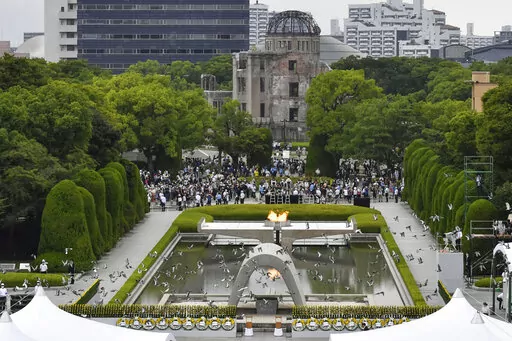 Doves fly over the cenotaph dedicated to the victims of the atomic bombing during the ceremony marking  the 77th anniversary of the world's first atomic bombing, at the Hiroshima Peace Memorial Park in Hiroshima, western Japan Saturday, Aug. 6, 2022. (Kyodo News via AP)