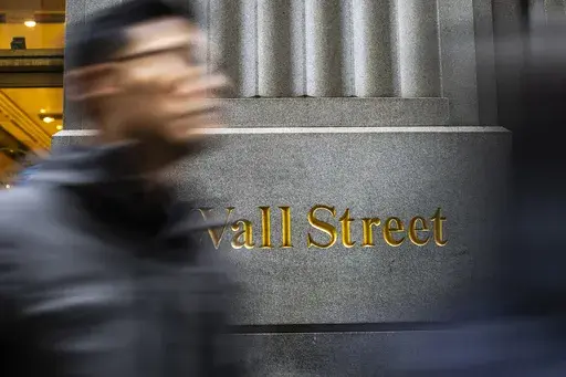 People walk on Wall St. near the New York Stock Exchange in New York, March 19, 2024. Know you should be investing but can’t quite bring yourself to do it? Feeling nervous about investing and other financial tasks is normal, but in some cases, it can be the result of financial trauma or abuse. (AP Photo/Eduardo Munoz Alvarez, File)