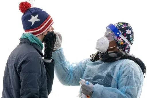 A man is swabbed for COVID-19 at a walk-up testing site at Farragut Square on Dec. 23, 2021, just blocks from the White House in Washington. The explosive increase in U.S. coronavirus case counts is raising alarm, but some experts believe the focus should instead be on COVID-19 hospital admissions. And those aren't climbing as fast. (AP Photo/Jacquelyn Martin, File )
