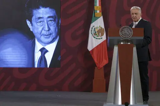 A photo of Japanese Prime Minister Shinzo Abe is displayed on the screen as Mexican President Andres Manuel Lopez Obrador offers his condolences following his death during his daily press conference at the National Palace in Mexico City, Friday, July 8, 2022. Former Prime Minister Shinzo Abe was assassinated Friday, July 8 in Japan by a gunman who opened fire on him as he delivered a campaign speech. (AP Photo/Moises Castillo)